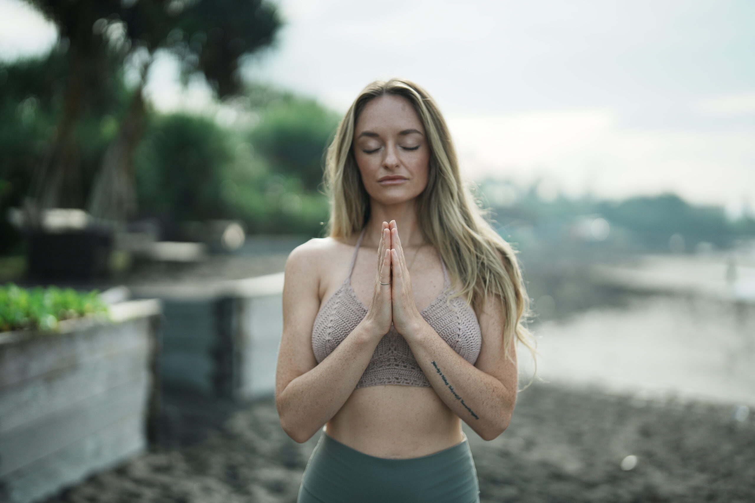 A person meditating with their eyes closed, surrounded by a serene environment with greenery in the background, symbolizing the concept of unlocking the subconscious mind through brain biohacking techniques.